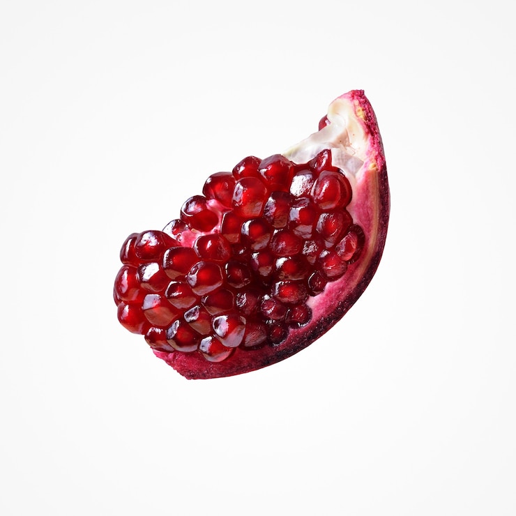 Photo composition de fruits subtropicaux. isoler la grenade de pièce rouge vibrante de jus sur le fond blanc de studio.