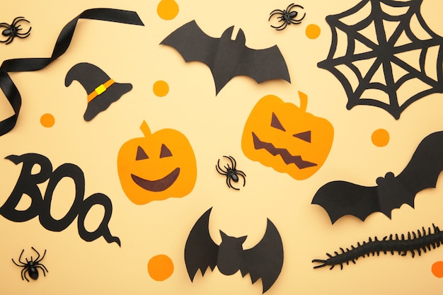 Composition d'Halloween avec des araignées et des chauves-souris sur fond de biege. Vue d'en-haut