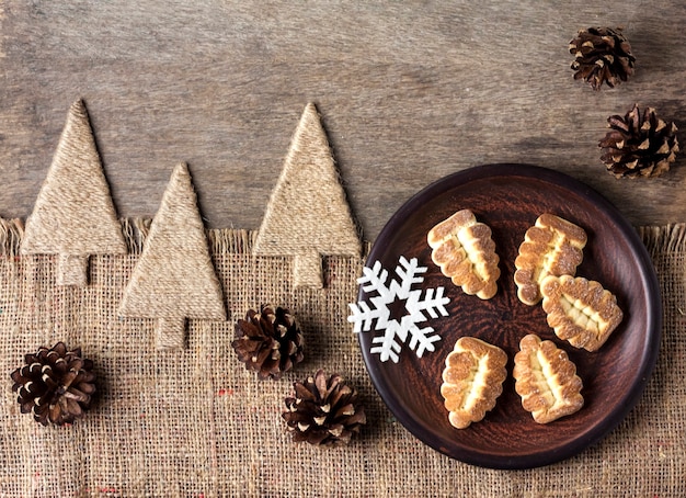 Composition d'hiver rustique avec des biscuits sablés sur une assiette et des pommes de pin