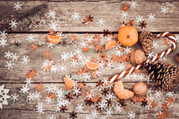 Photo composition d'hiver avec sucette, pommes de pin, noix et mandarine