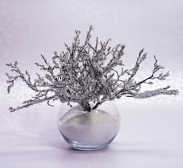 Composition hivernale élégante avec une branche de givre dans un vase en verre