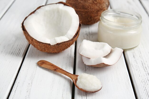 Photo composition avec de l'huile de noix de coco fraîche sur fond de bois