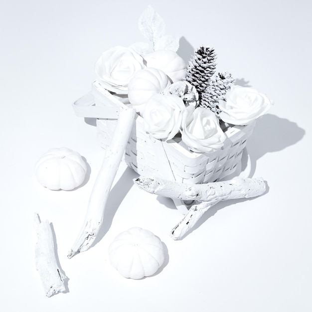 Composition isométrique minimale d'hiver Panier avec des roses de cônes blancs et citrouille Art de la nature morte