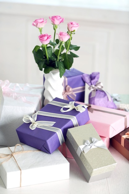 Composition de jolis coffrets cadeaux et roses sur tableau blanc