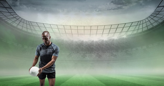 Composition d'un joueur de rugby masculin tenant un ballon de rugby sur un stade de sport