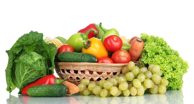 Composition avec légumes et fruits dans un panier en osier isolé sur blanc