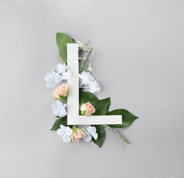 Composition avec lettre L et belles fleurs sur fond de couleur