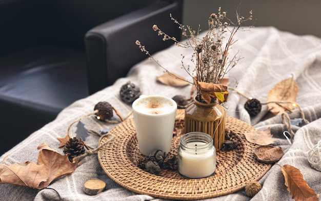 Composition de maison confortable avec une tasse de café une bougie et des détails décoratifs