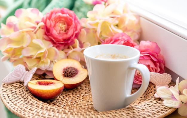 Composition maison avec une tasse de fleurs de café et un élément tricoté