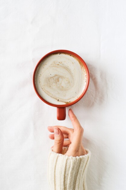 Composition de minimalisme avec tasse de café et main sur fond blanc