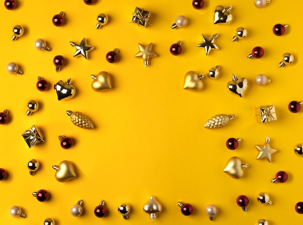 Composition moderne de Noël. Décorations dorées sur fond jaune.