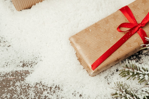 Composition neigeuse avec un cadeau de Noël sur une table en bois