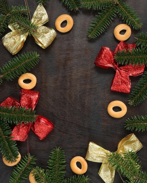 Composition de noël avec des arcs lumineux, des branches de sapin, des bagels et un espace vide au centre