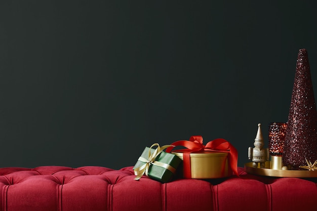 Composition de Noël sur le banc de velours rouge avec décoration, cadeaux, couronne, lanterne et accessoires. Espace de copie. Couleur rouge et verte. Modèle.