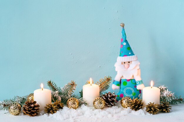 Composition de Noël bleu. Bougies et nain parmi les branches de sapin