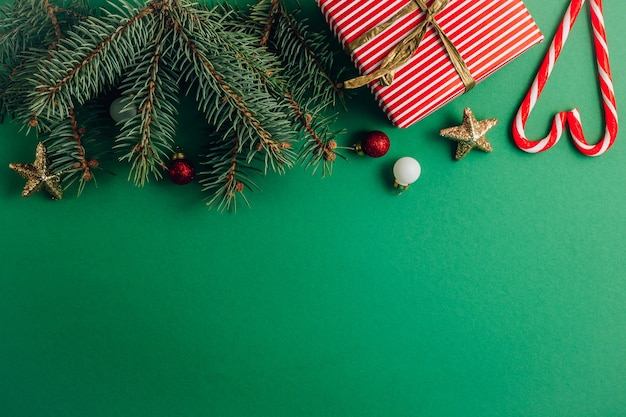 Composition de Noël. Bordure faite d'arbres, décorations rouges et dorées sur vert.