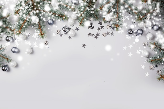 Composition de Noël avec des branches de sapin, boules d'argent sur fond clair pastel. Joyeux Noël carte. Vacances d'hiver. Bonne année.