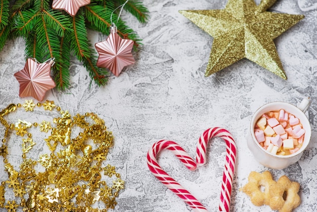 Composition de Noël de branches vertes d'épinette, guirlande du Nouvel An, jouets, tasse avec guimauves et sucettes