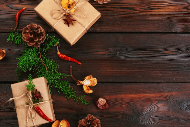 Composition de Noël, cadeau de Noël, couverture tricotée, pommes de pin, branches de sapin sur fond en bois,