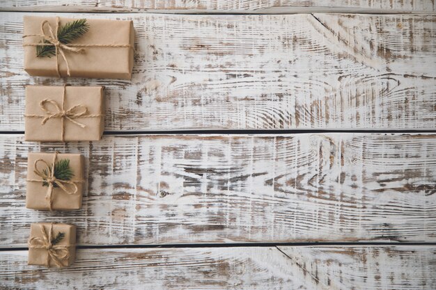 Composition de noël Cadeau de Noël, pommes de pin, branches de sapin sur fond blanc en bois.