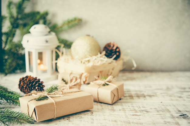 Composition de noël Cadeau de Noël, pommes de pin, branches de sapin sur fond blanc en bois.