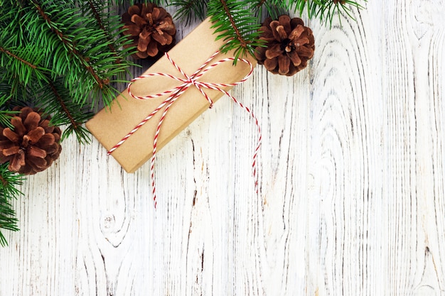 Composition de Noël. Cadeau de Noël avec des pommes de pin et des branches de sapin sur fond en bois. Mise à plat, vue de dessus, fond. Tonifié