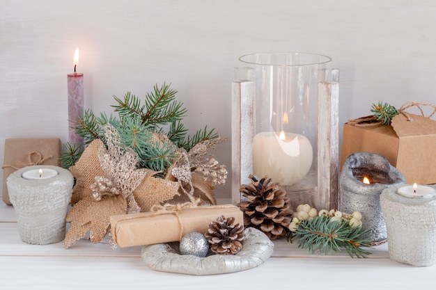 Composition de Noël avec des cadeaux de bougies de jouets du Nouvel An sur une atmosphère chaleureuse de fond blanc