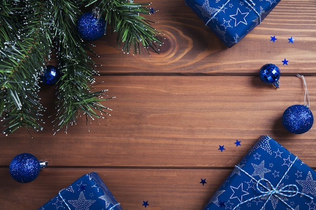 Composition de Noël. Cadeaux, branches de sapin, décorations bleues sur bois. Noël, hiver, concept de vacances de nouvel an. Mise à plat, vue de dessus, espace copie