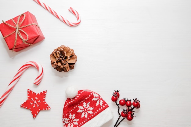 Composition de noël Cadeaux, cônes de sapin, décorations rouges sur fond blanc.