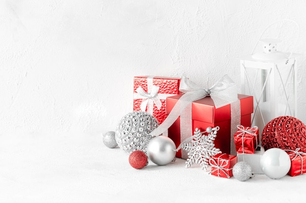 Composition de Noël avec des cadeaux rouges et blancs sur l'espace de copie de table blanche
