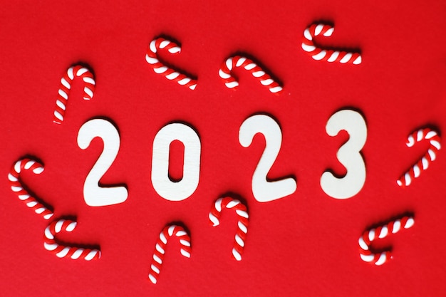 Composition de Noël avec cannes de bonbon et numéro 2023 sur fond rouge Copiez l'espace pour le texte