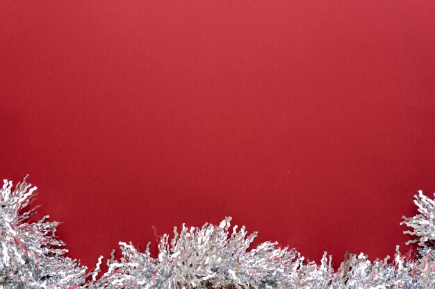 Composition de Noël. Décoration de Noël guirlande blanche sur fond rouge. Mise à plat, vue de dessus, espace pour le texte