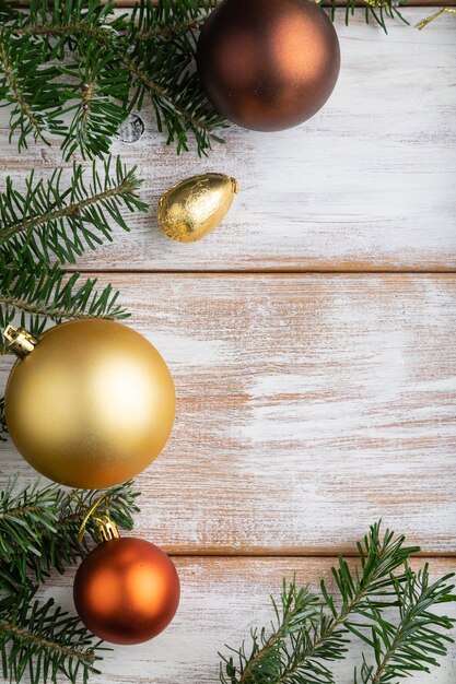 Composition de Noël. Décorations, boîte, boules d'or, branches de cannelle, sapin et épicéa, tasse de café sur table en bois blanc. Vue de dessus.
