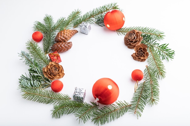 Composition de Noël. Décorations, boules, cônes, branches de sapin et d'épinette sur blanc.