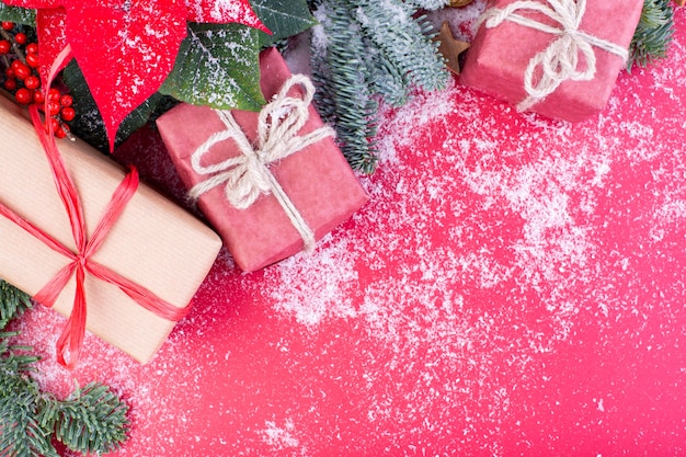 Composition de Noël. Décorations de Noël rouges, branches de sapin avec coffrets cadeaux jouets sur fond rouge. Mise à plat, vue de dessus, espace de copie.
