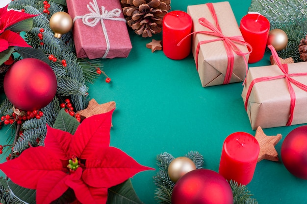 Composition de Noël. Décorations vertes de Noël, branches de sapin avec des coffrets cadeaux jouets sur fond vert. Mise à plat, vue de dessus, espace copie