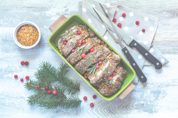 Composition de Noël et du Nouvel An avec une délicieuse viande cuite au four avec des canneberges et des épices branches d'épinette couverts sur une surface gris clair vue de dessus copie épice