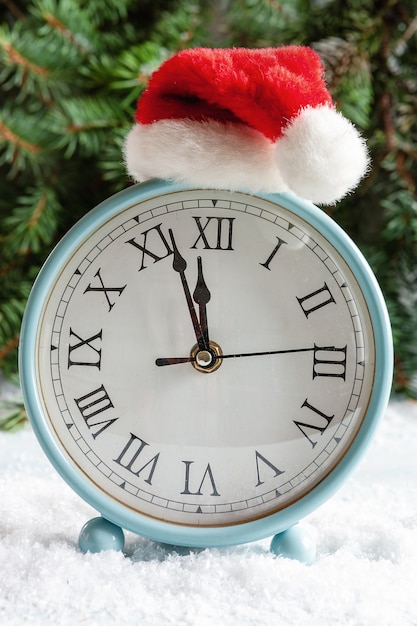 Composition de Noël et du Nouvel An avec une horloge dans un bonnet de Noel montrant la veille des vacances