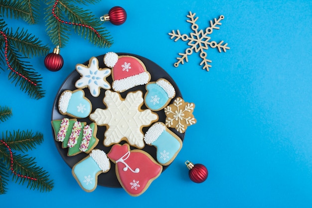 Composition de Noël avec du pain d'épice sur la plaque noire sur fond bleu. Vue de dessus. Espace de copie.