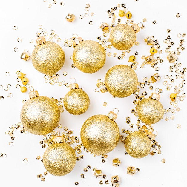 Photo composition de noël faite de boules de noël dorées sur fond blanc. mise à plat, vue de dessus