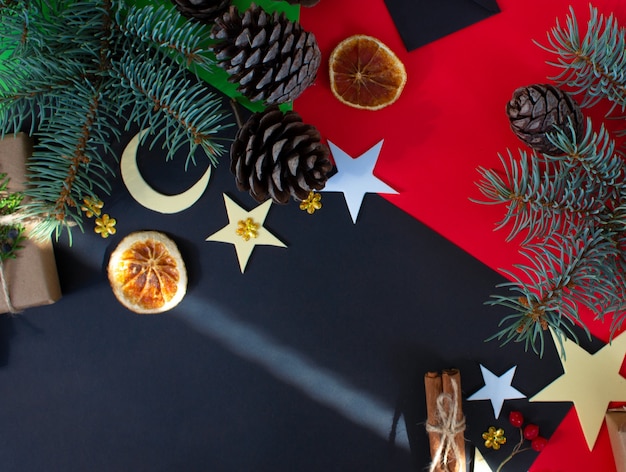 Composition de Noël sur fond rougenoir cadeaux de Noël pommes de pin décorations de Noël