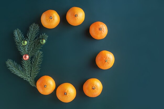 Composition de Noël sur fond vert. Arbre de Noël avec jouets et mandarines fraîches.