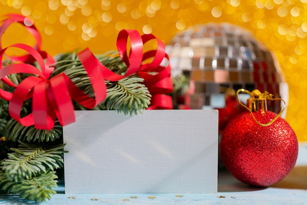 Composition de Noël sur jaune. Branches d'épinette, de serpentine rouge et de boules.