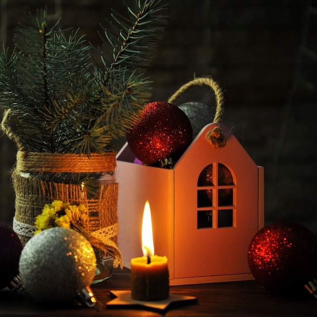 Composition de Noël avec des jouets de Noël, une bougie et une petite maison