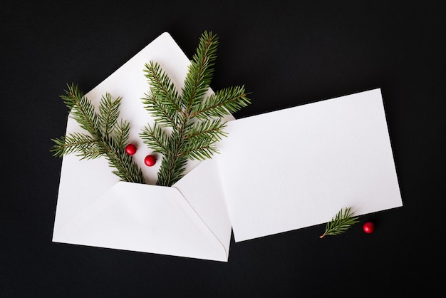 Composition de Noël avec lettre de félicitations. Décor de nouvel an avec branche de sapin et baie de houx. Notion de nouvel an. Mise à plat, vue de dessus, espace de copie