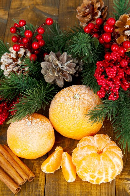 Composition de Noël avec des mandarines mûres givrées sur fond de bois