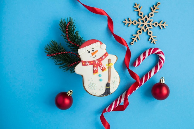 Composition de Noël de pain d'épice en forme de bonhomme de neige sur fond bleu Vue de dessus Espace de copie