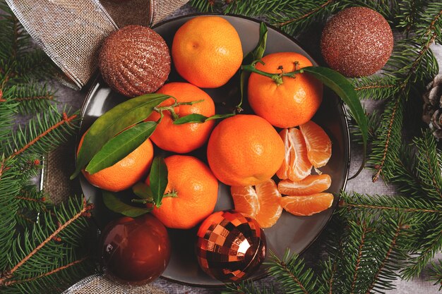 Composition de Noël sur plaque avec oranges et sapin, sur fond gris