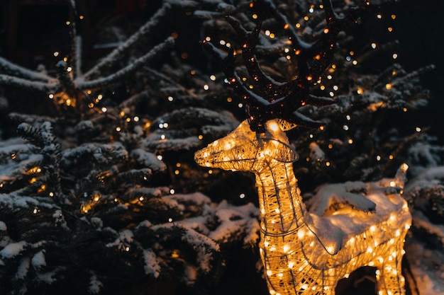 Composition de Noël en plein air de vacances avec illumination de guirlande dorée et cerf magique