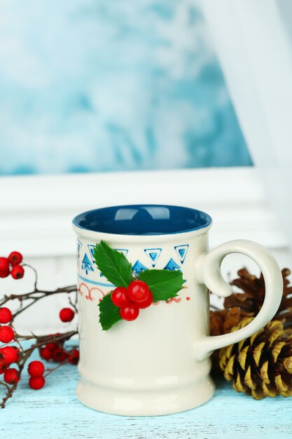 Composition de Noël avec tasse de boisson chaude, sur table en bois